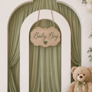 שלט עץ אלון תלוי בחריטת לייזר עם הכיתוב Baby Boy ולב, על קיר אירוע בקשת עם וילונות ירוקים, בלונים ודובי