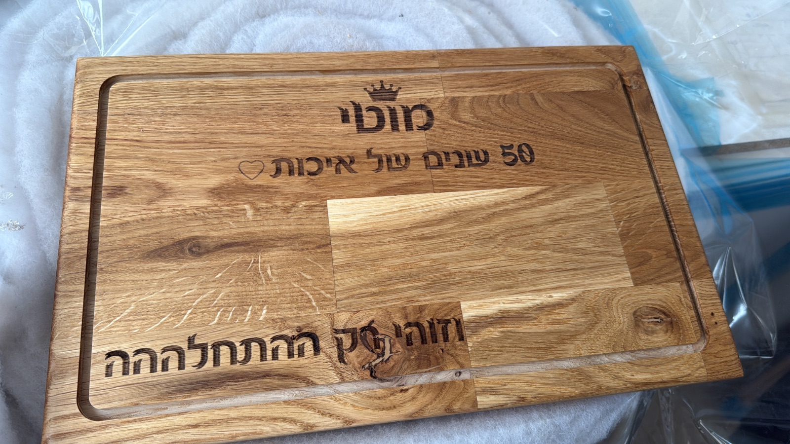קרש חיתוך מעץ אלון מסיבי במידה 25/40 ס"מ עם חריטת לייזר אישית של שם, כתר וברכה ותעלת ניקוז היקפית