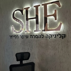 לוגו תלת מימד מואר בתאורת LED אחורית על קיר בטון בכניסה לעסק