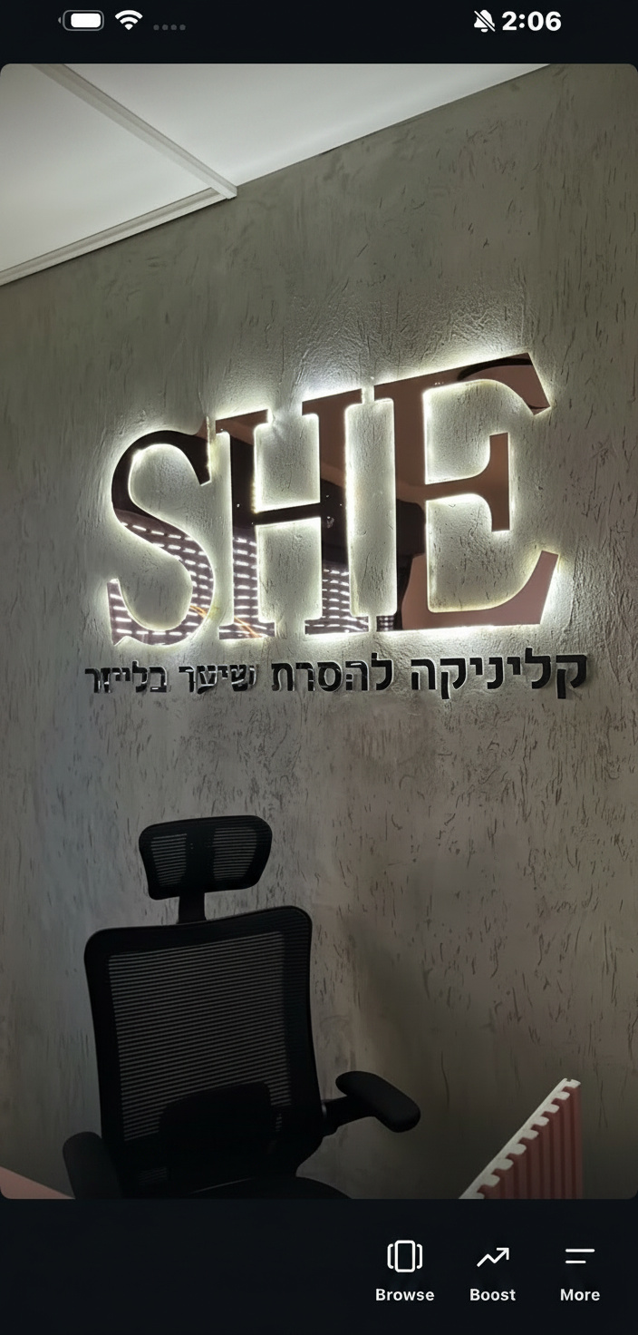 לוגו תלת מימד מואר בתאורת LED אחורית על קיר בטון בכניסה לעסק